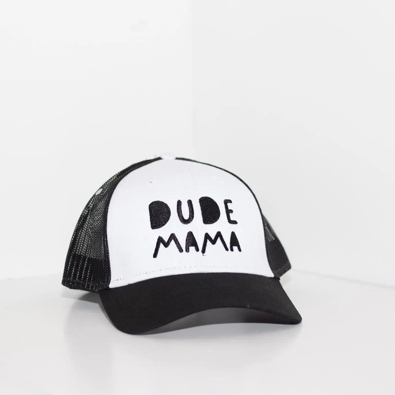 Black and white boy mom hat. The hat says 'Dude Mama' and is on a light gray background