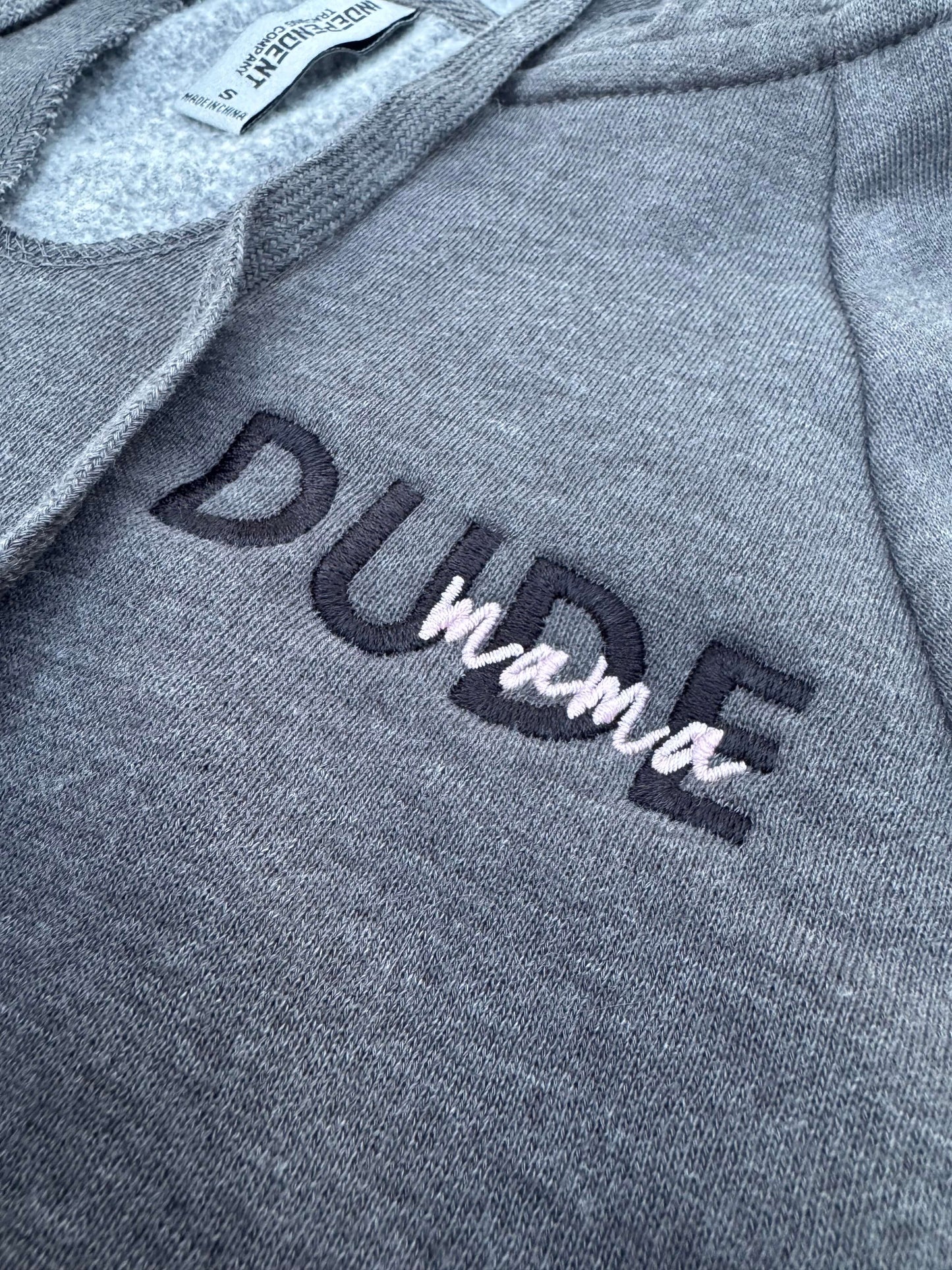 Close-up of the embroidered text on a dark gray Dude Mama sweatshirt, ideal for boy moms. Boy Mom Sweatshirt.