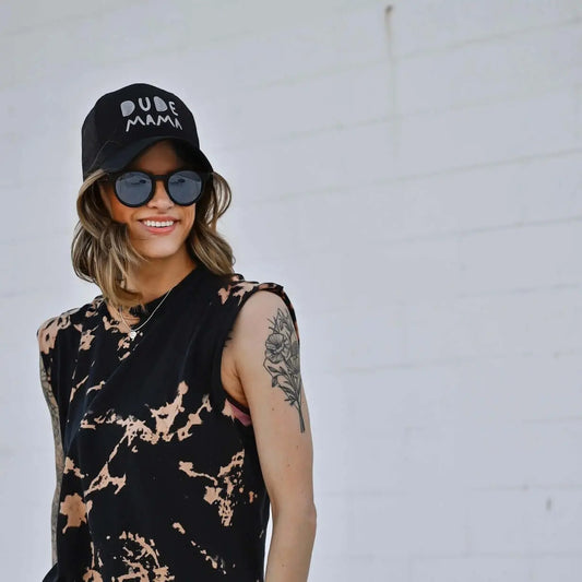 Woman wearing a black Dude Mama hat and sunglasses, showcasing the boy mom hat style. Boy mom hat