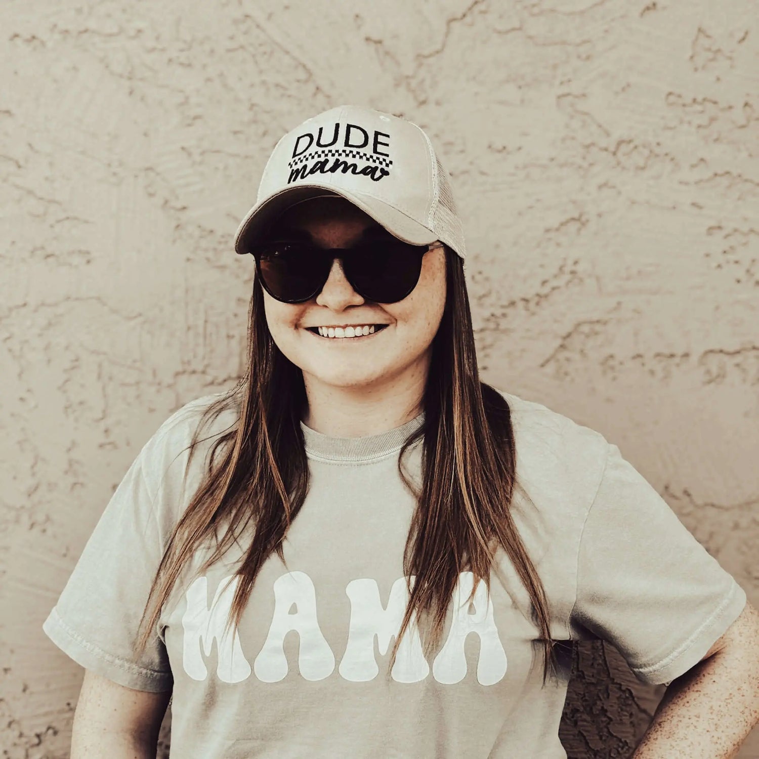Smiling woman wearing a Tan Checkered Dude Mama Hat and sunglasses, representing a stylish boy mom hat.