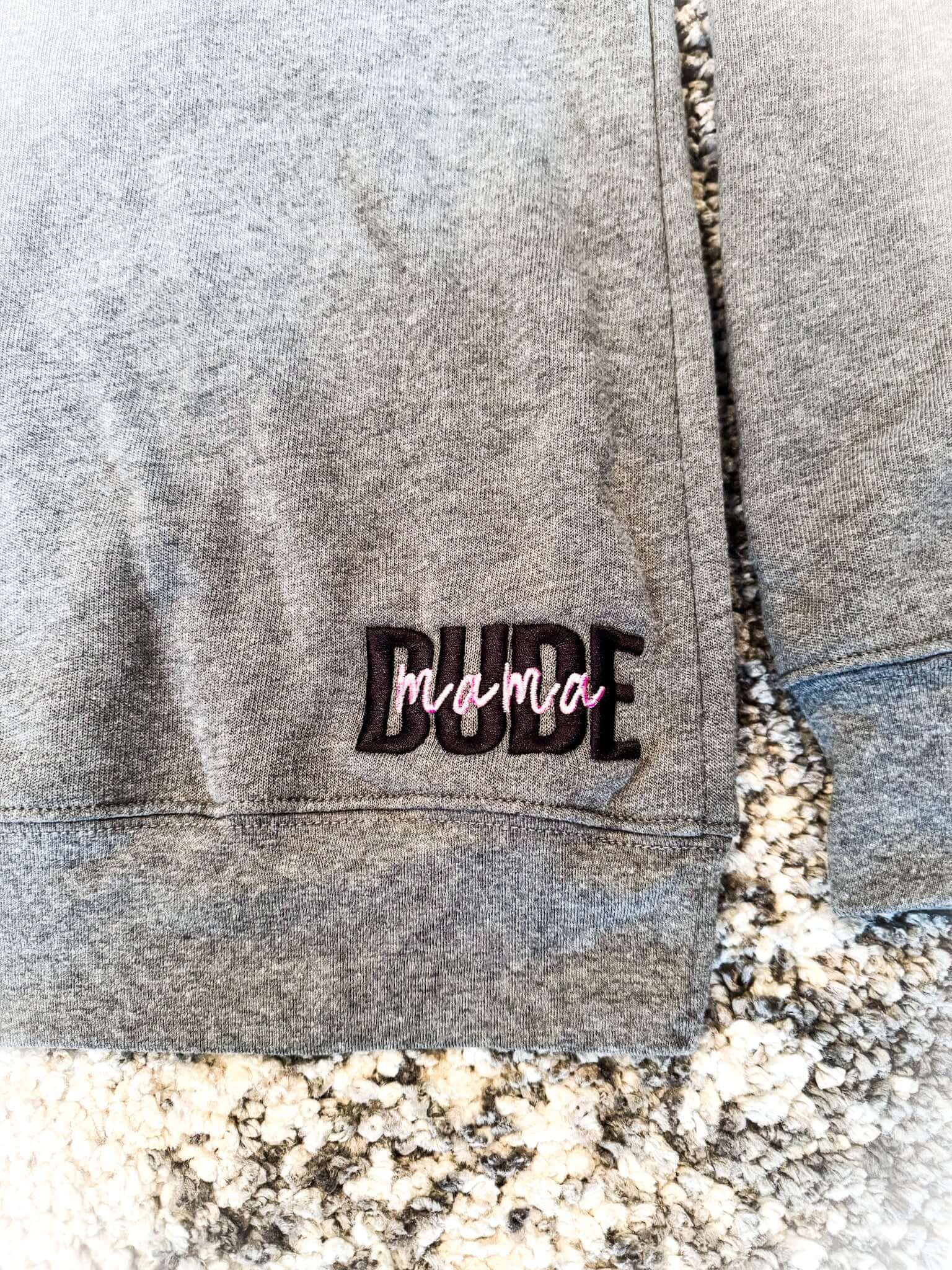 Close-up of the gray Dude Mama Boy Mom Sweatshirt featuring the stylish 'Dude' embroidery.