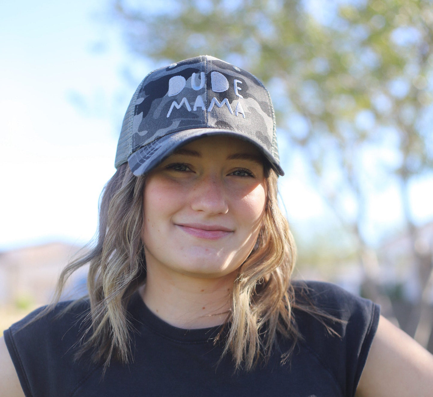 Woman wearing a camo boy mom hat