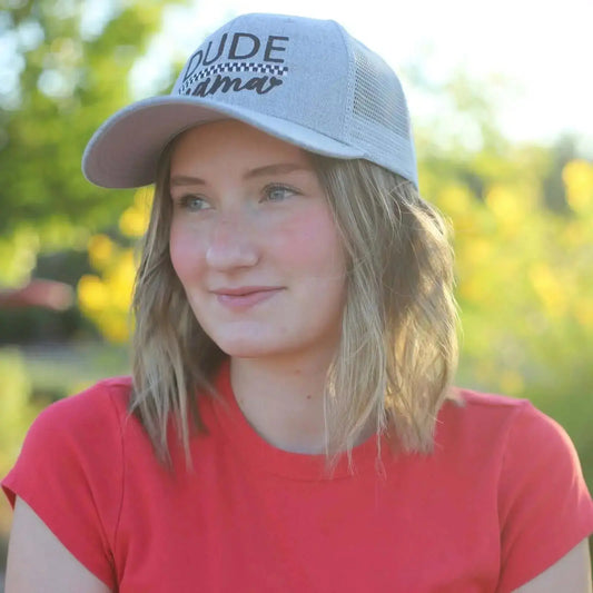 Light gray checkered boy mom hat worn by a young woman with a bright background, showcasing style and confidence.