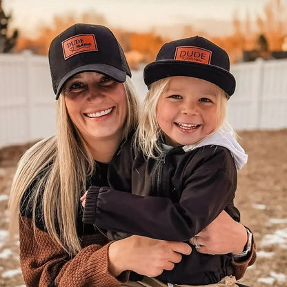 Matching black hats for mom and son, featuring patches, perfect for family moments outdoors. Boy mom hat and Dude hat
