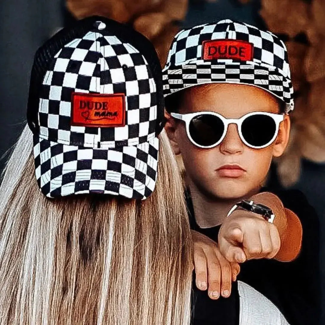 Mom and son are wearing matching mom and son hats with a checkered design. 